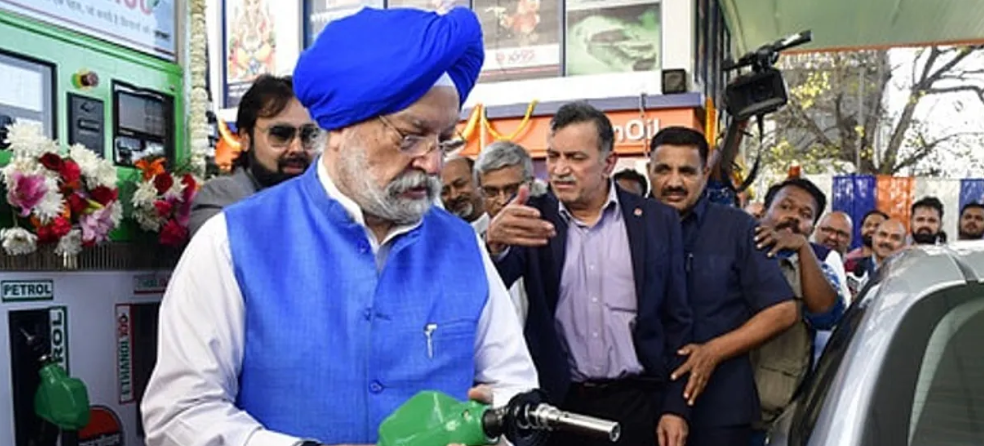 Vehicle being refueled with E20 petrol at a fuel station in India.