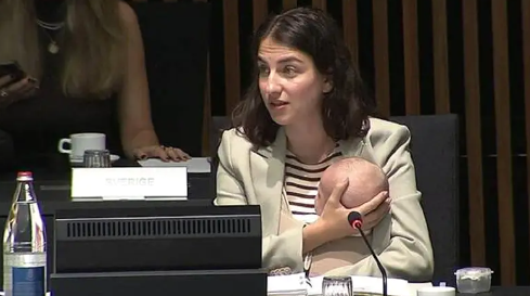 Swedish Climate Minister Romina Pourmokhtari holding her baby during an official cabinet meeting.